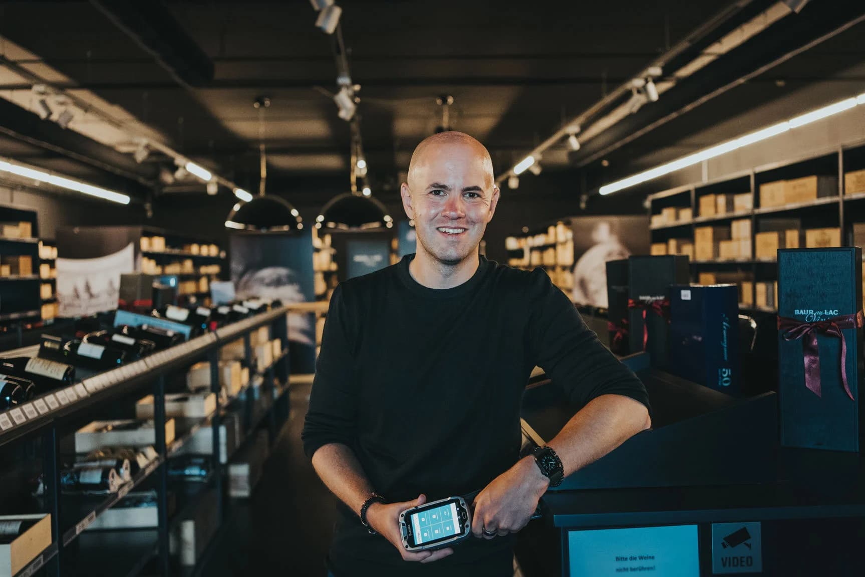 Daniel%20Hunziker%2C%20SAP-Administrator%20bei%20Baur%20au%20Lac%20Vins%2C%20mit%20mobilem%20Scanner%20im%20Lagerverkauf%20als%20Beispiel%20f%FCr%20den%20Einsatz%20SAP-integrierter%20mobiler%20Datenerfassung%20f%FCr%20hohe%20Bestandsgenauigkeit%20und%20effiziente%20Logistikprozesse.