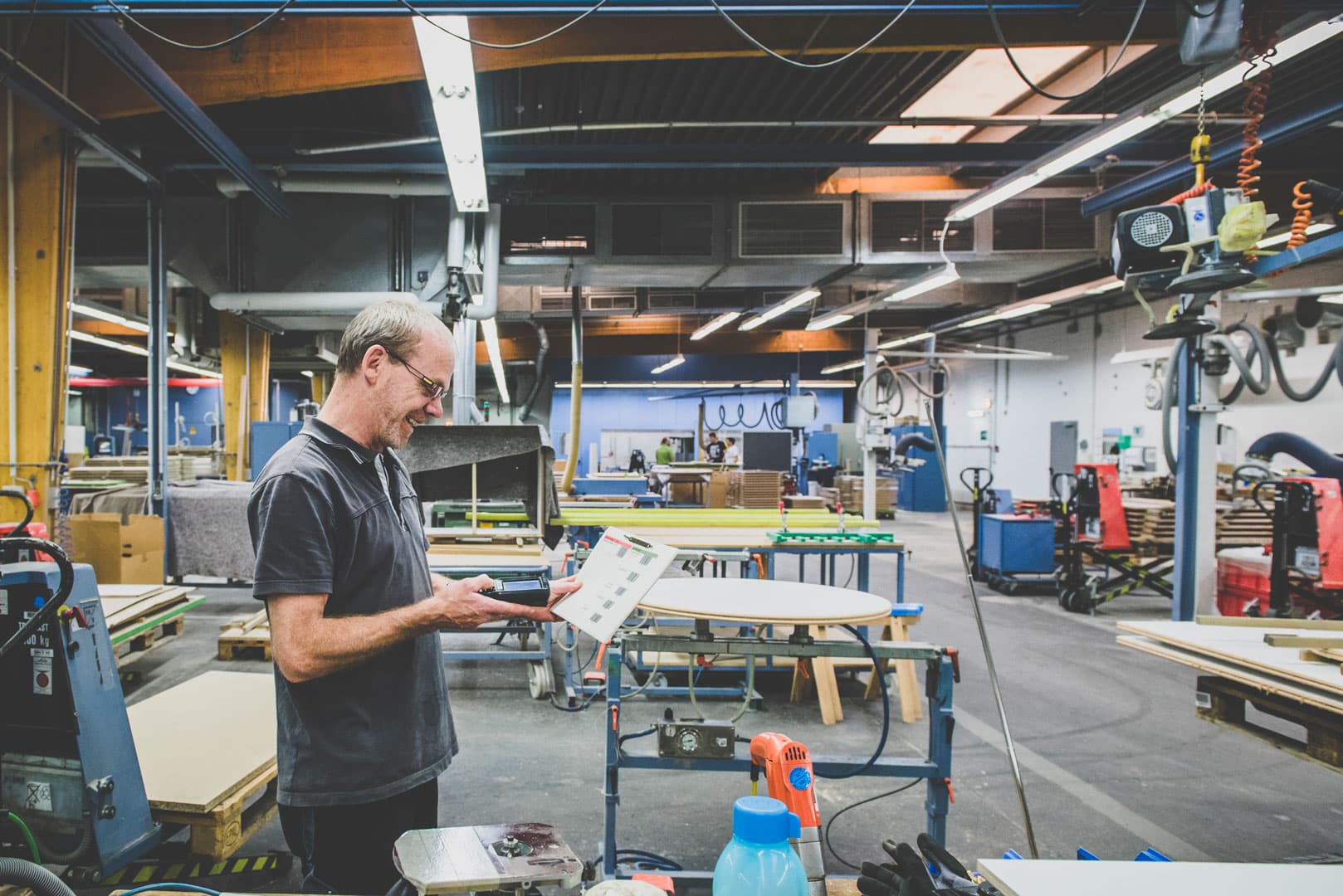 Mitarbeiter%20in%20einer%20Fertigungshalle%20mit%20mobilem%20Scanner%20und%20Arbeitsbeleg%20zur%20Erfassung%20von%20Vorgangsdaten%2C%20um%20SAP%20relevante%20Zeiten%20im%20Produktionsprozess%20zu%20buchen.