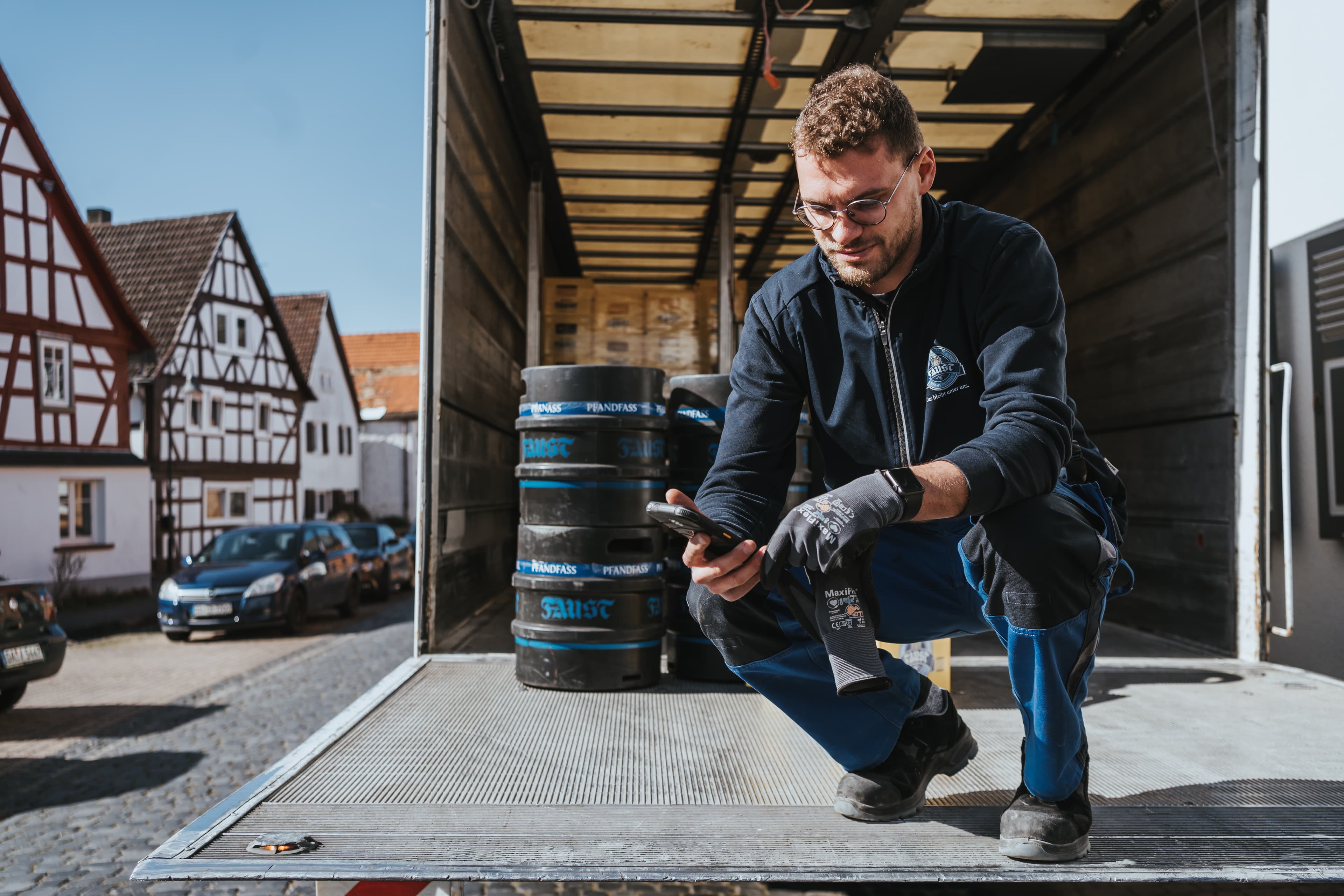 Fahrer%20l%E4dt%20Bierf%E4sser%20aus%20dem%20Lkw%20und%20nutzt%20eine%20OntegoGL%20mobile%20App%20zur%20digitalen%20Lieferabwicklung.